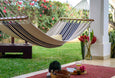 Artisan hammock in a peaceful courtyard, paired with rattan furniture and linen textiles for a relaxed boho-luxury setting.