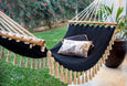 Full-length view of Boho Noir hammock displayed in a garden lounge setting with natural lighting