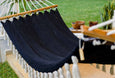 Full-length view of Boho Noir hammock displayed in a garden lounge setting with natural lighting