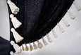 Close-up of artisan white hand-tied tassels on black cotton hammock