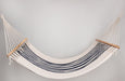 Colonial-style hammock with wooden bar, elegantly styled on a patio with bohemian accents and soft natural light.