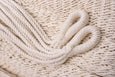 Detail view of natural cotton weave and fringe on a handmade hammock