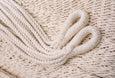 Close-up of detail on natural cotton hammock with teak spreader bar