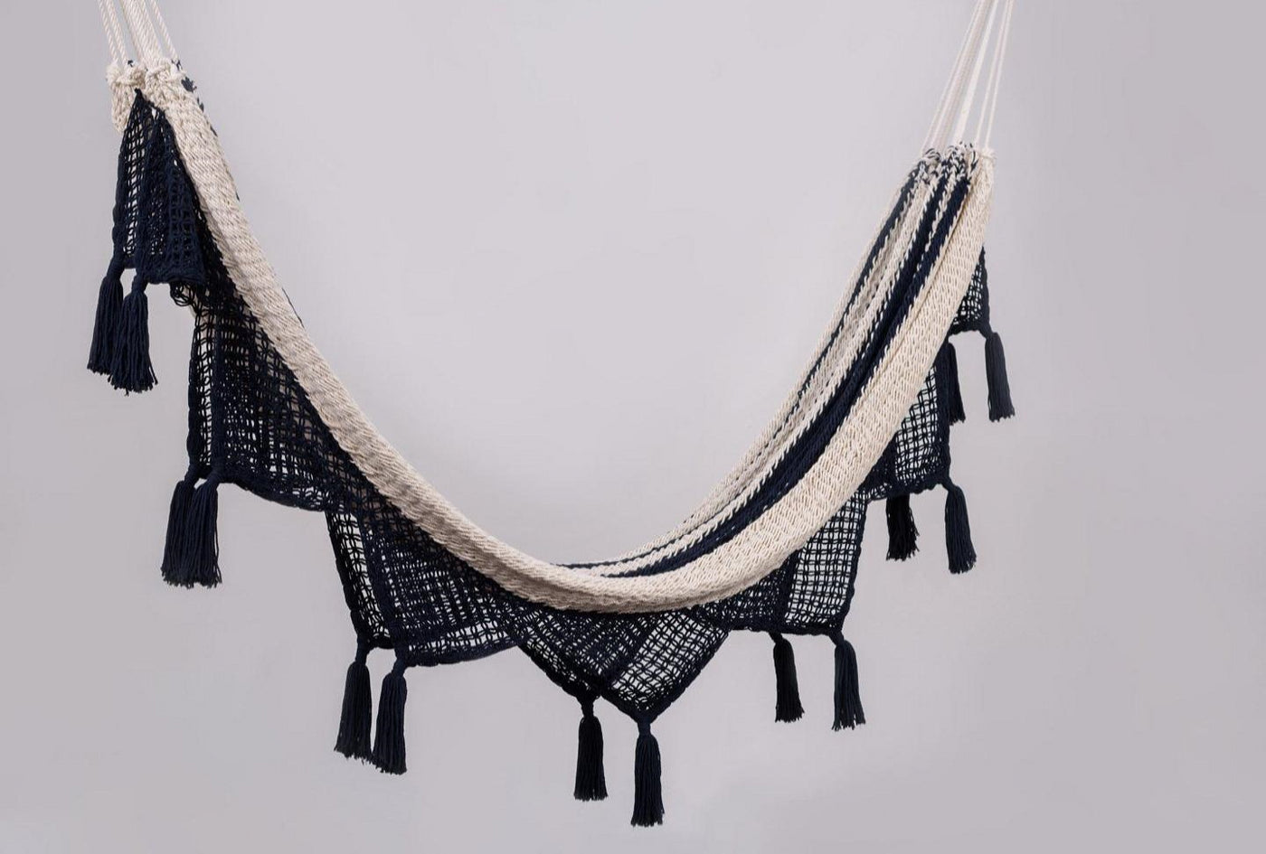 Handwoven colonial navy cotton hammock with elegant hand-tied tassels draped indoors